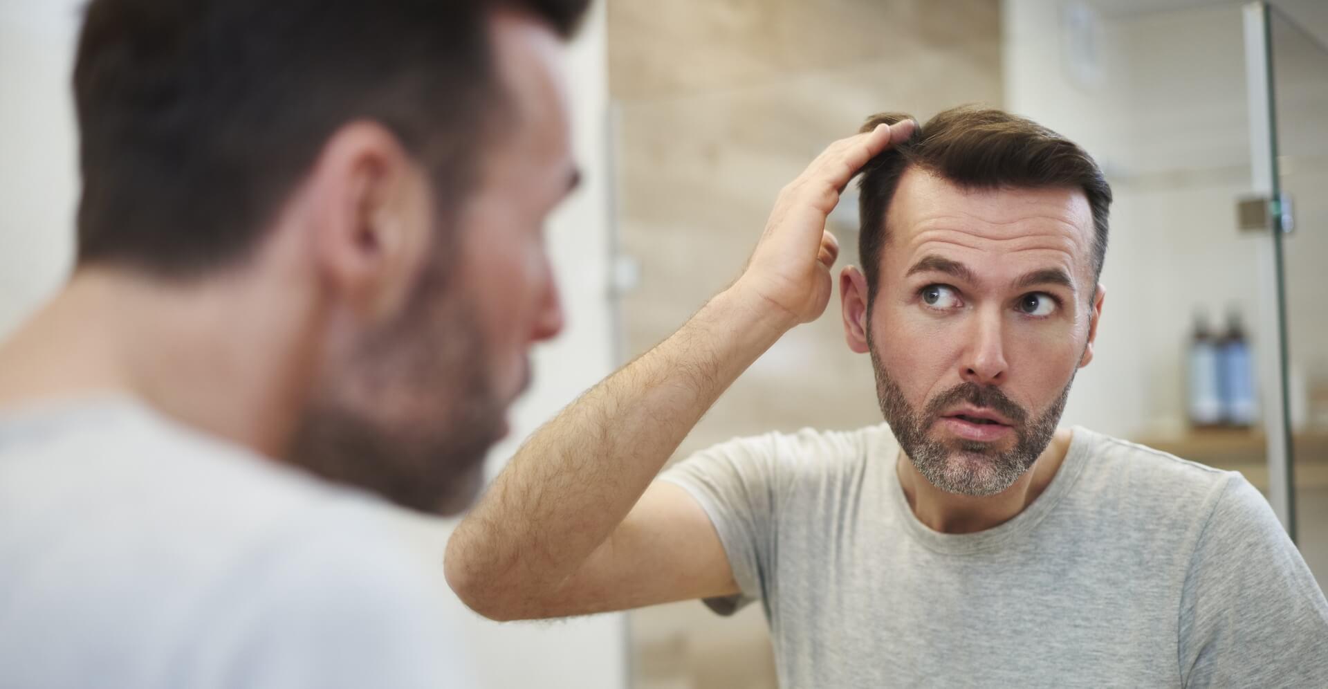 Homme se coiffant dans un miroir